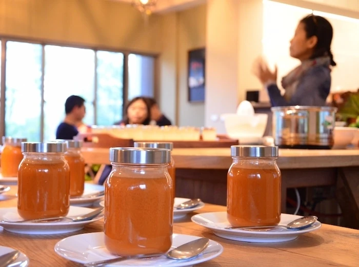 Jars of carrot juice on the table with retreat participants in the background