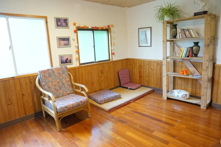 A bright volunteer common room with chairs, books and a wooden floor