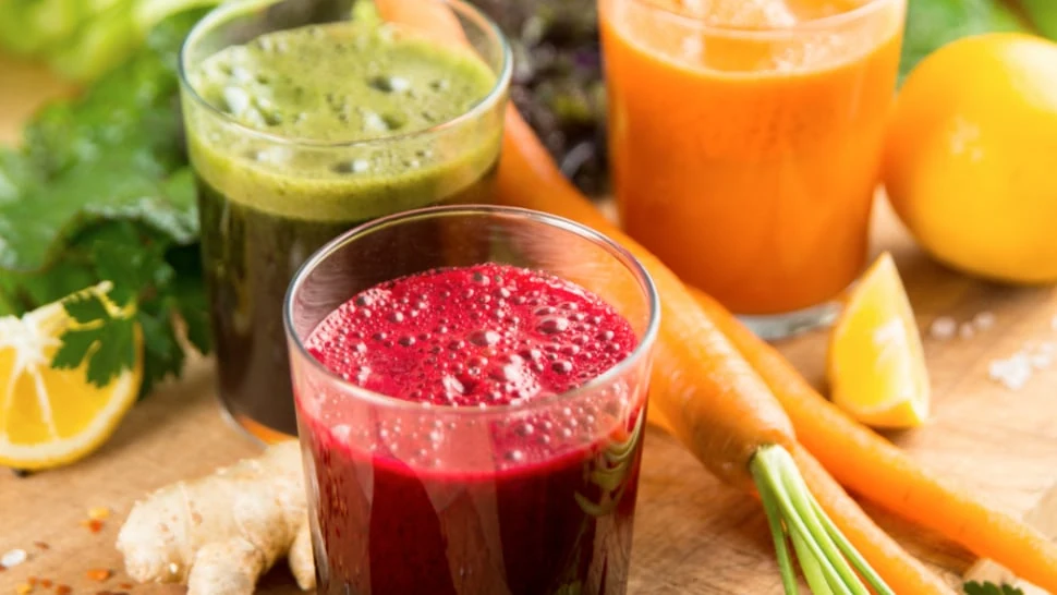 Glasses of green, orange and red fruit and vegetable juices