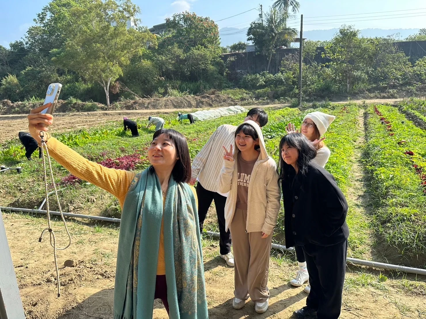 Retreat participants taking a photograph beside the vegetable fields